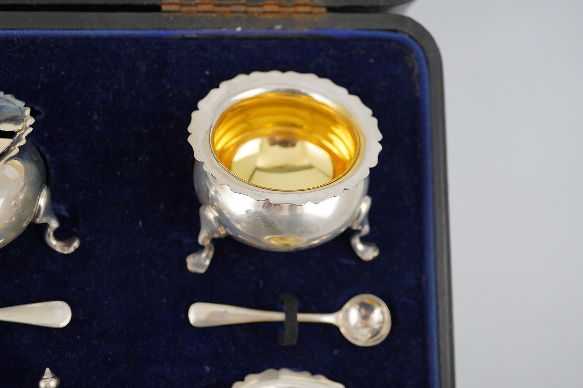 A George V cased silver seven piece condiment set by Horace Woodward & Co Ltd, Birmingham, 1918, with five associated silver condiment spoons. Condition - poor to fair